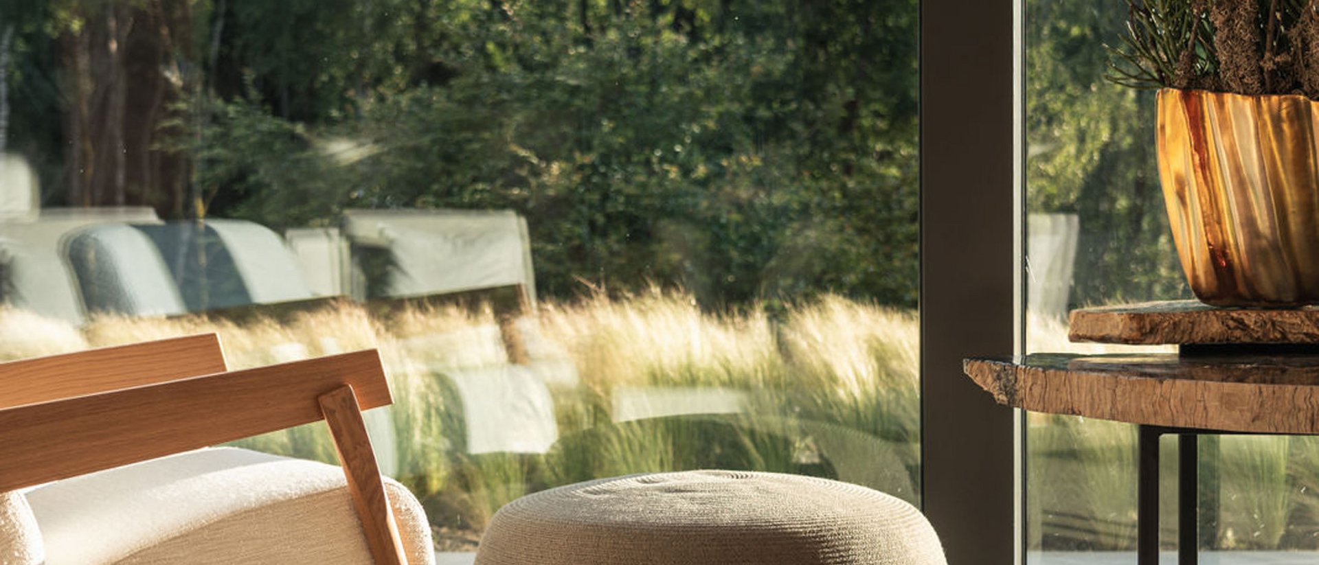 Seezeitlodge : Galerie photos Fauteuil à bascule confortable, pouf et table près d'une grande fenêtre avec vue sur la verdure