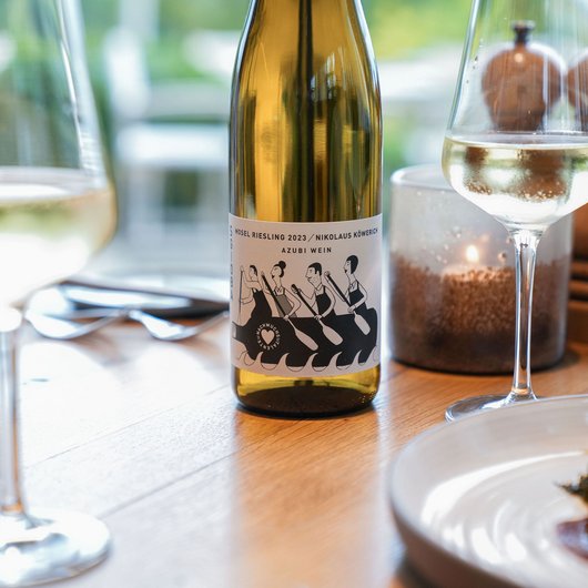 LUMI: our restaurant at Lake Bostalsee Mosel Riesling 2023 wine bottle with two wine glasses on wooden table