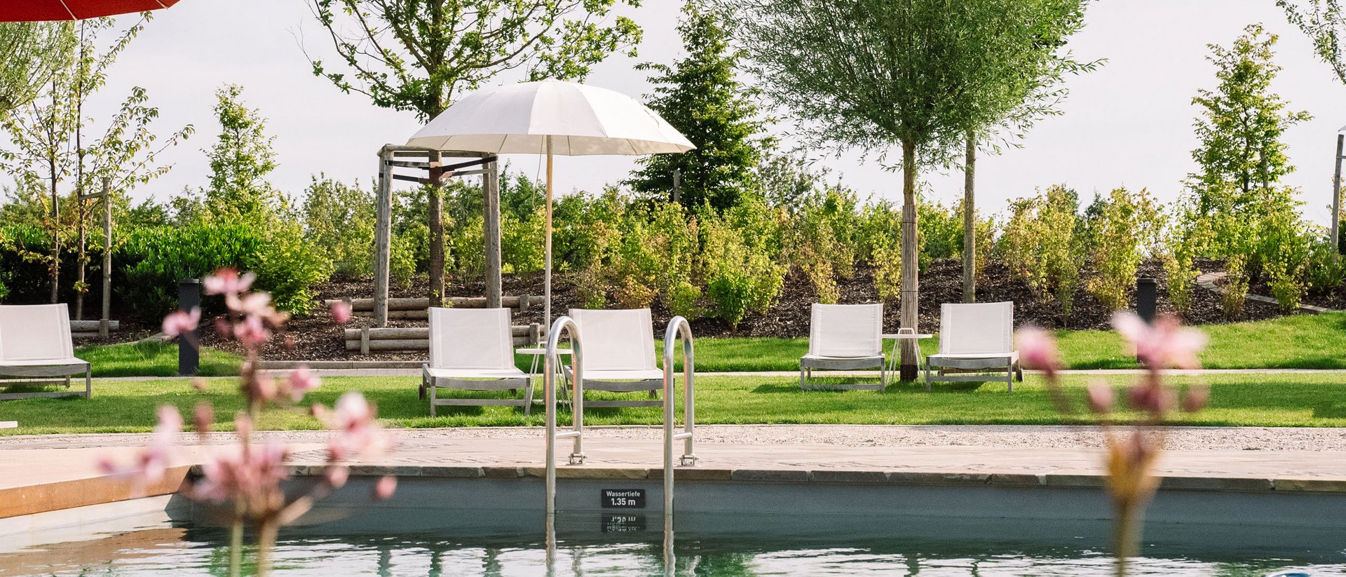 Seezeitlodge: Bildergalerie Schwimmbecken mit Liegestühlen und Sonnenschirmen in Grünanlage