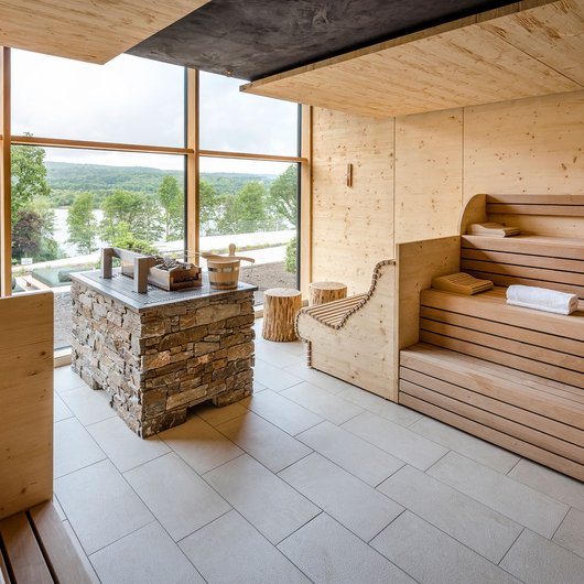 Seezeitlodge: Ihr Spa-Hotel am Bostalsee Moderne Sauna mit Holzinterieur und großem Fenster mit Blick auf grüne Landschaft