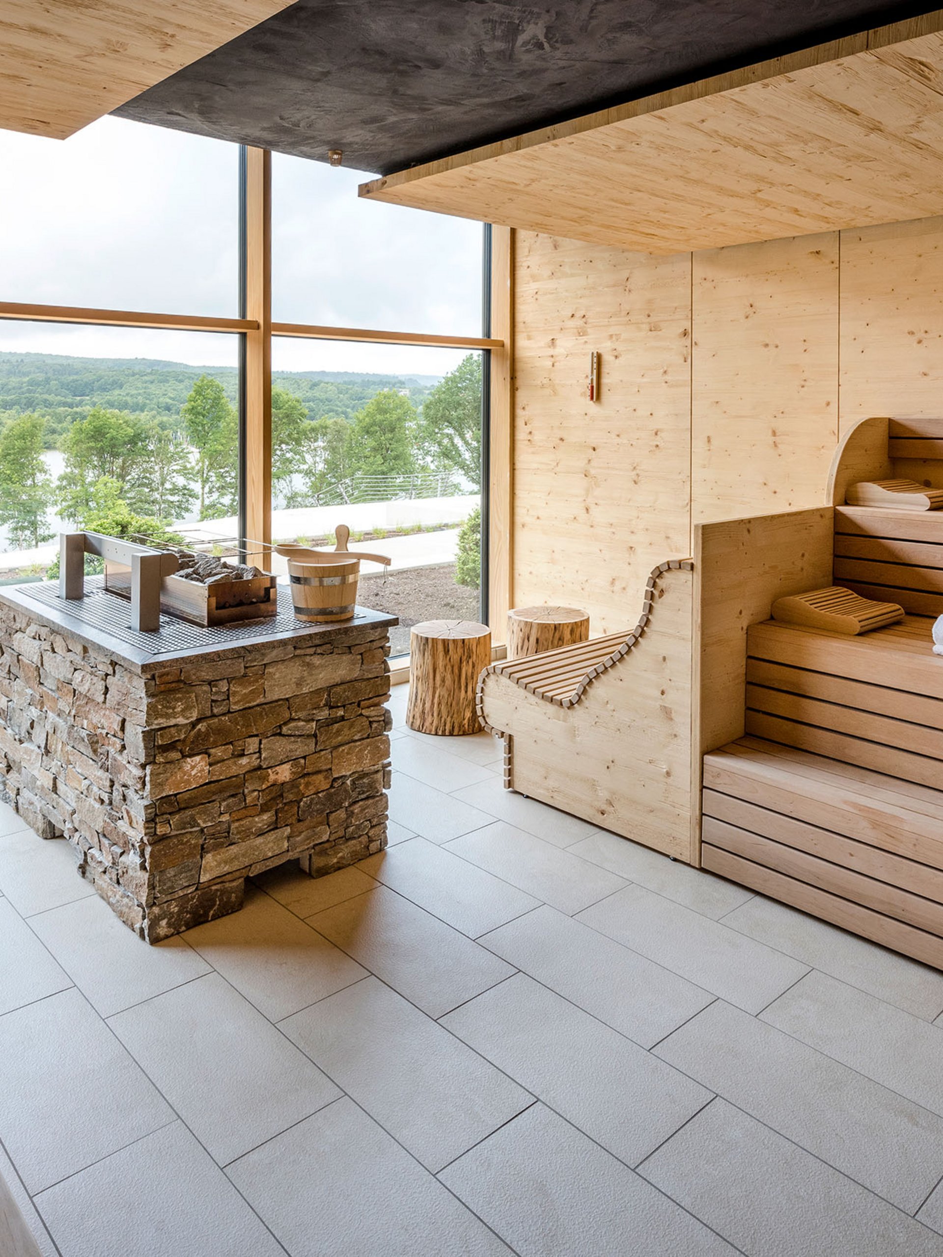 Seezeitlodge: Bildergalerie Moderne Sauna mit Holzinterieur und großem Fenster mit Blick auf grüne Landschaft