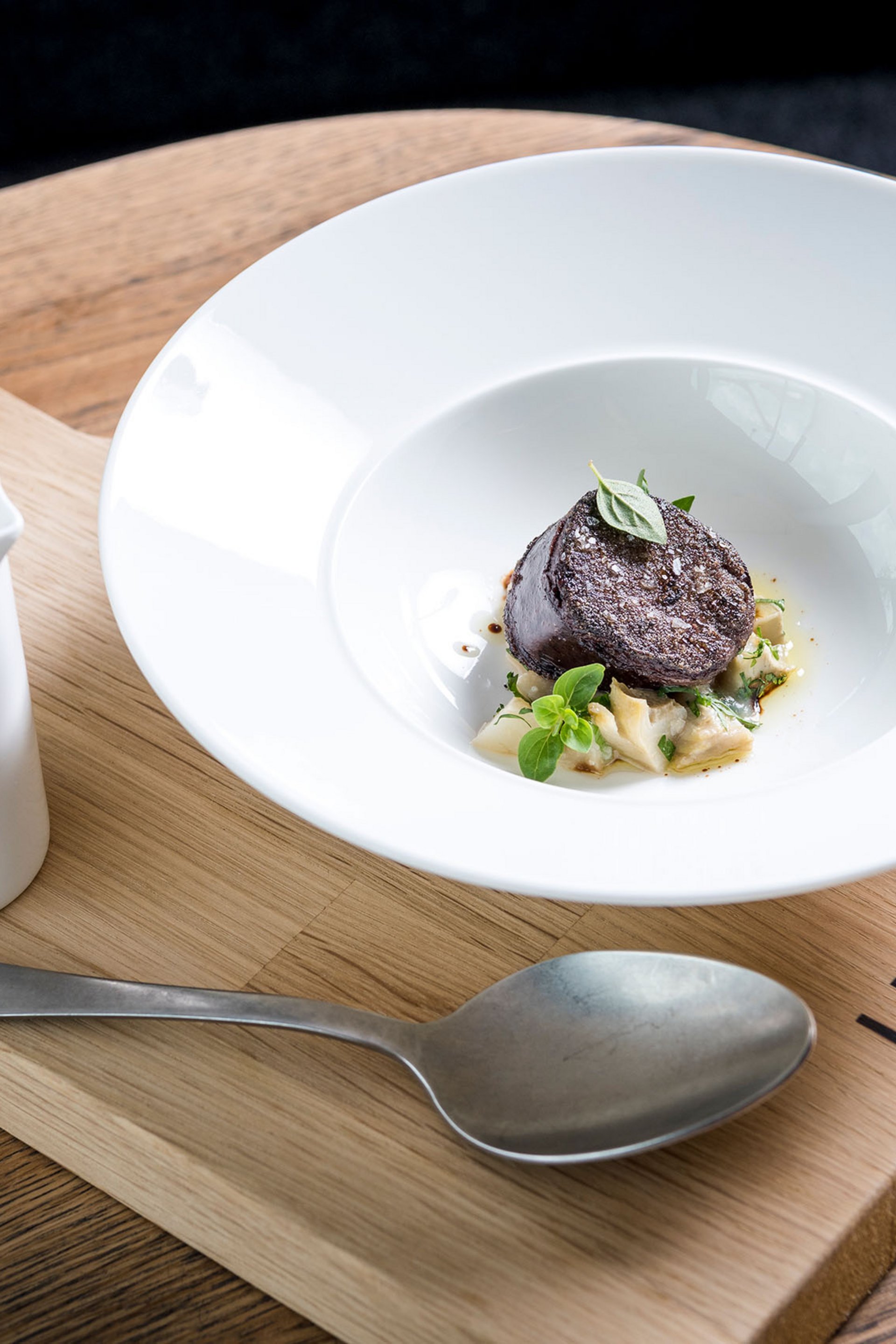 Seezeitlodge : Galerie photos Plat gastronomique élégant avec sauce sur planche en bois au restaurant Lumi