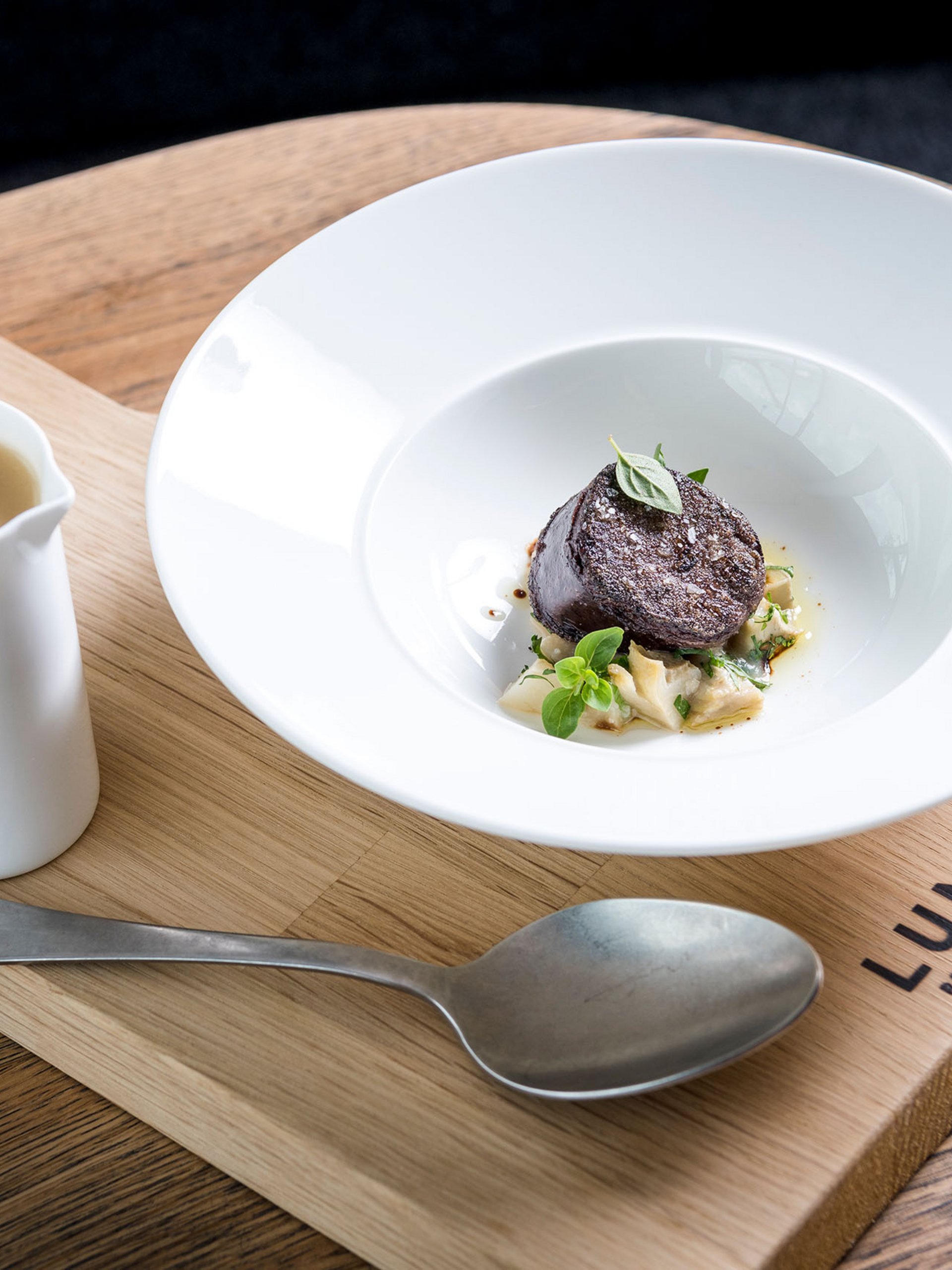 Seezeitlodge : Galerie photos Plat gastronomique élégant avec sauce sur planche en bois au restaurant Lumi