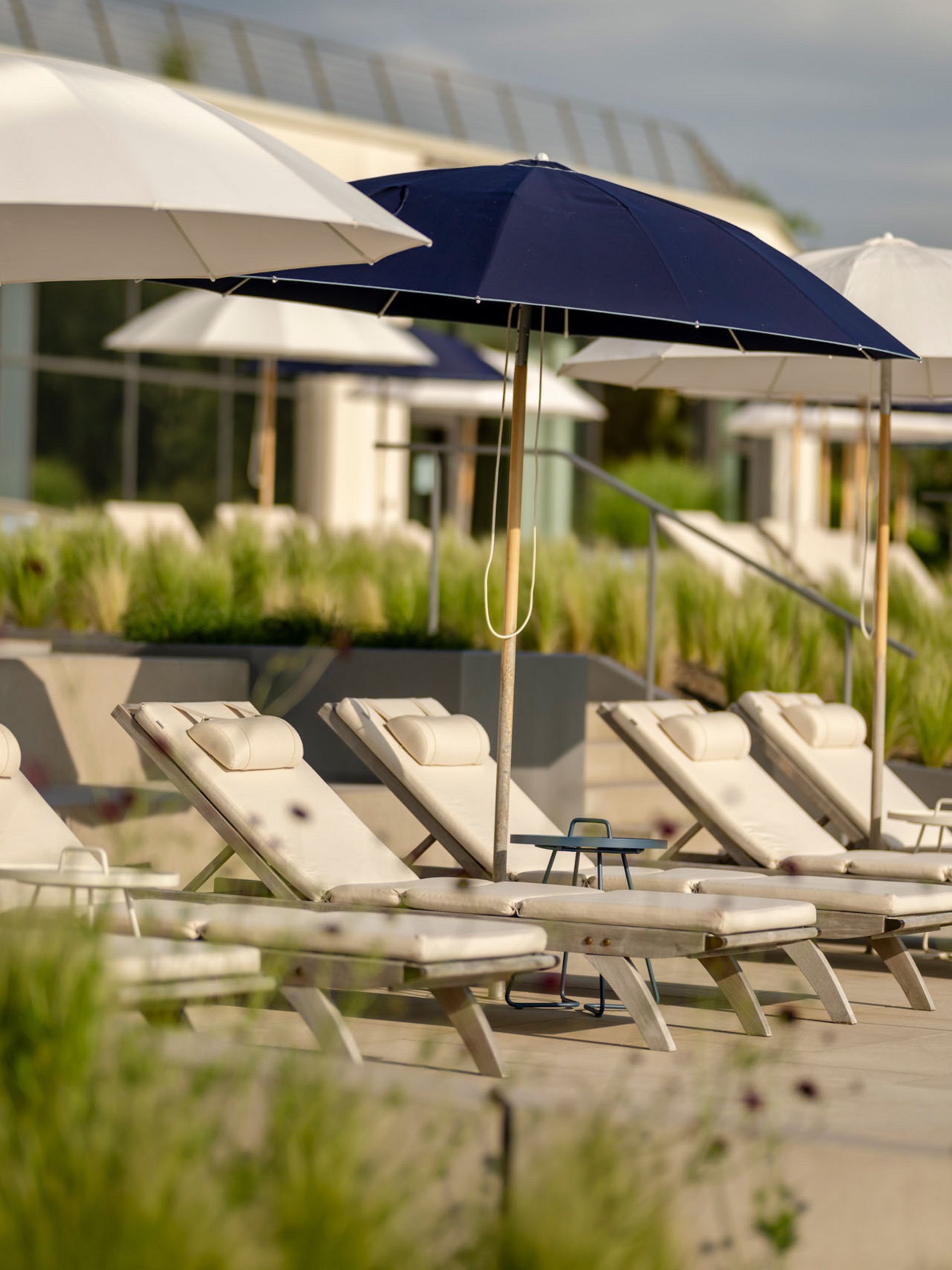 Seezeitlodge : Galerie photos Chaises longues vides avec parasols dans une zone de piscine ensoleillée