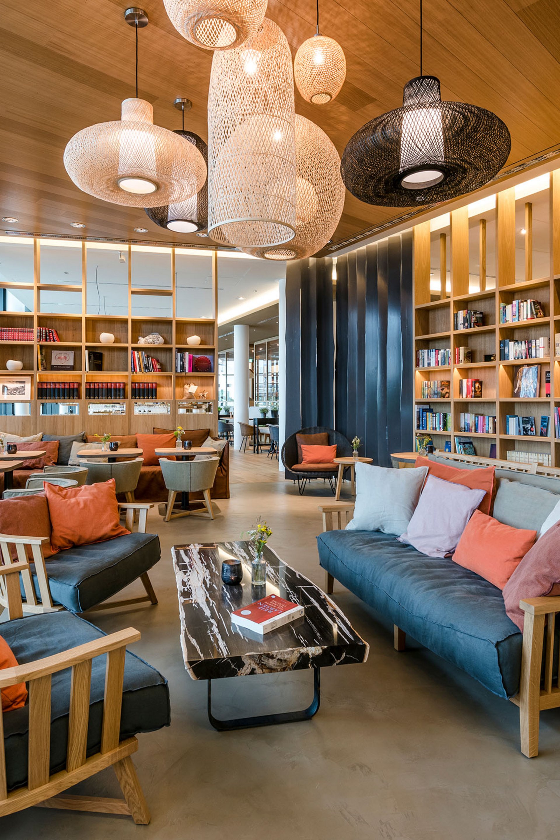 Seezeitlodge : Galerie photos Bibliothèque moderne avec canapés confortables, étagères en bois et suspensions