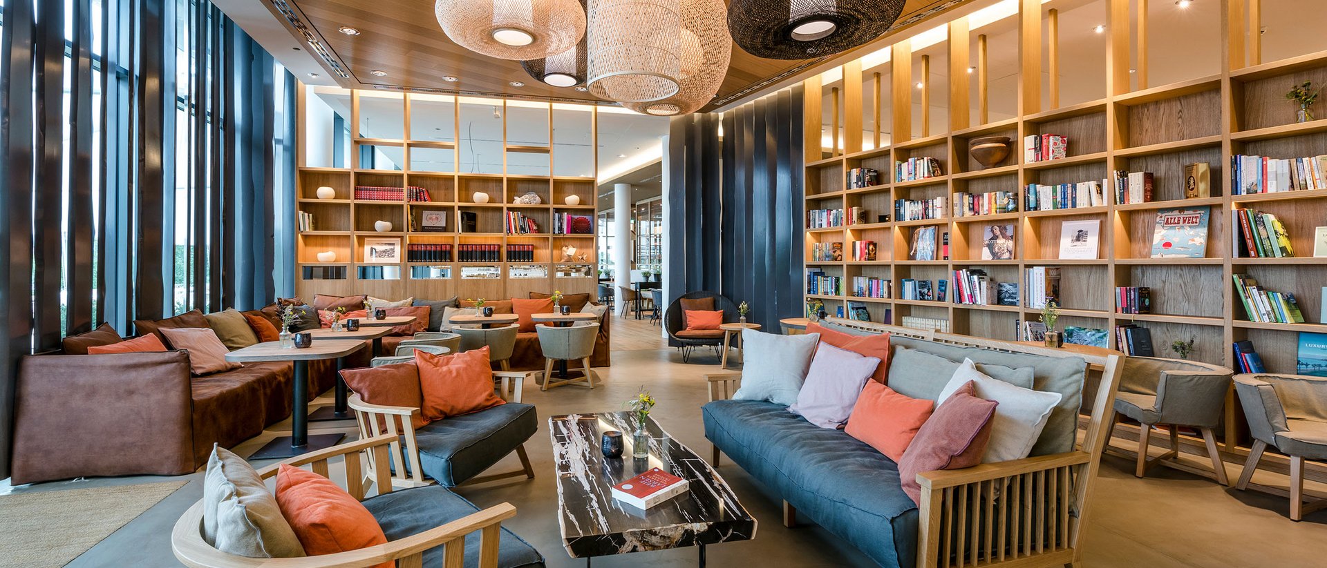 Seezeitlodge : Galerie photos Bibliothèque moderne avec canapés confortables, étagères en bois et suspensions