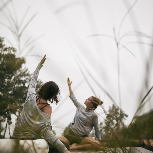 Ihr Wellnesshotel mit Yoga in Deutschland Zwei Frauen machen Yogaübungen im Freien auf einer Matte